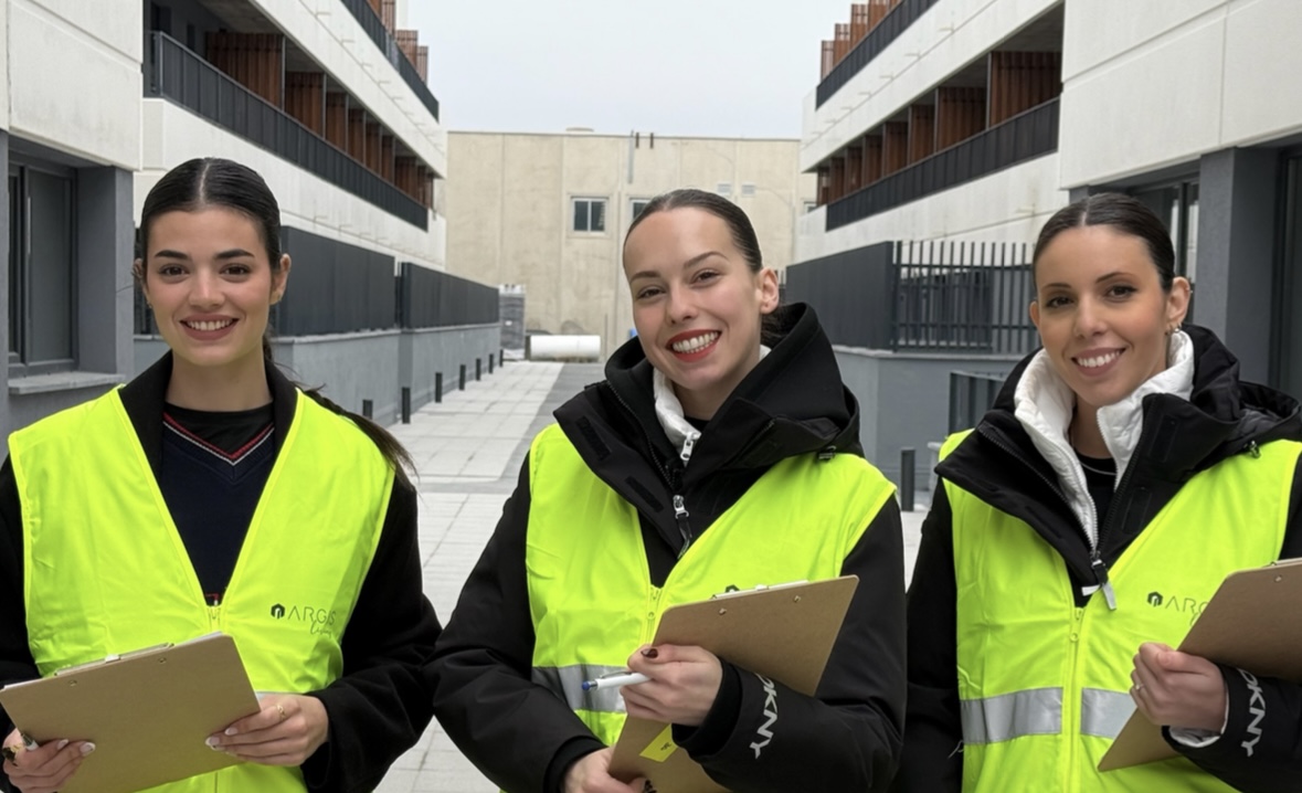 Azafata recibiendo a clientes durante una visita de cortesía en un inmueble de alto nivel.