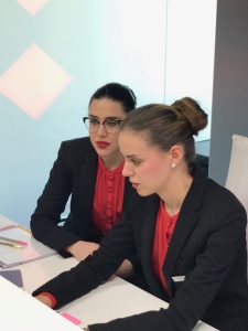 Dos azafatas de ACHE Azafatas trabajando en equipo en un puesto de recepción corporativa.