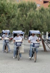 Promotores en triciclos personalizados repartiendo publicidad de Turris