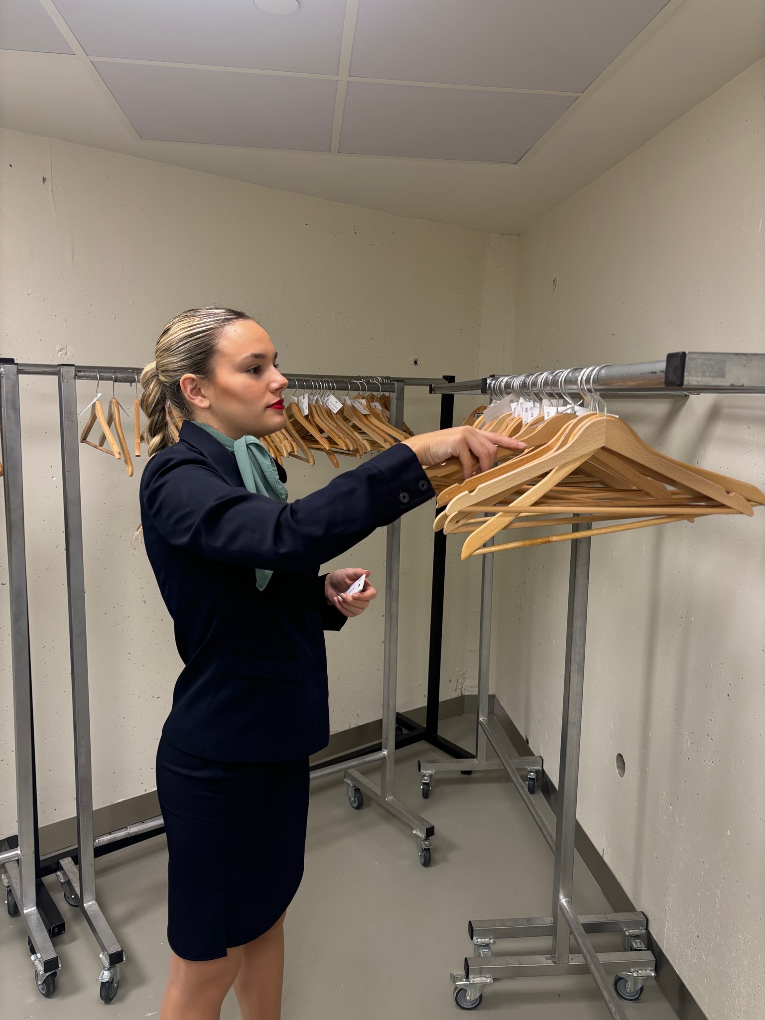 Azafata sonriendo mientras ofrece información en evento