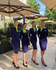 Azafatas de Protocolo profesionales en evento premium en los jardines del Hotel Ritz Madrid, uniformadas con elegancia en azul marino y pañuelo verde lima. Imagen corporativa impecable, atención al cliente de alto nivel y protocolo para eventos exclusivos. Personal de imagen para eventos de lujo, congresos, recepciones y marcas de alto standing. Servicios de azafatas en Madrid por ACHE Azafatas.