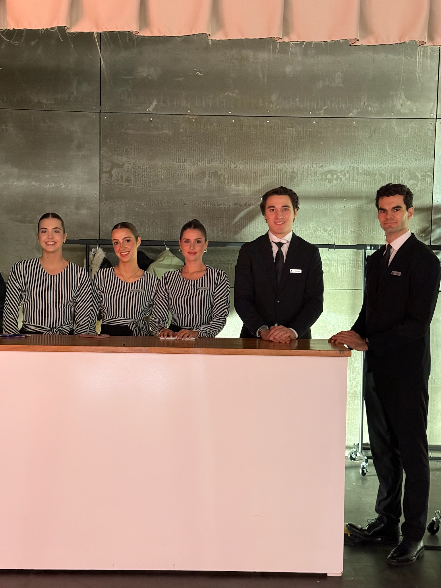 Azafatas en guardarropa organizando prendas durante un evento profesional de EMESTUDIOS en Madrid.