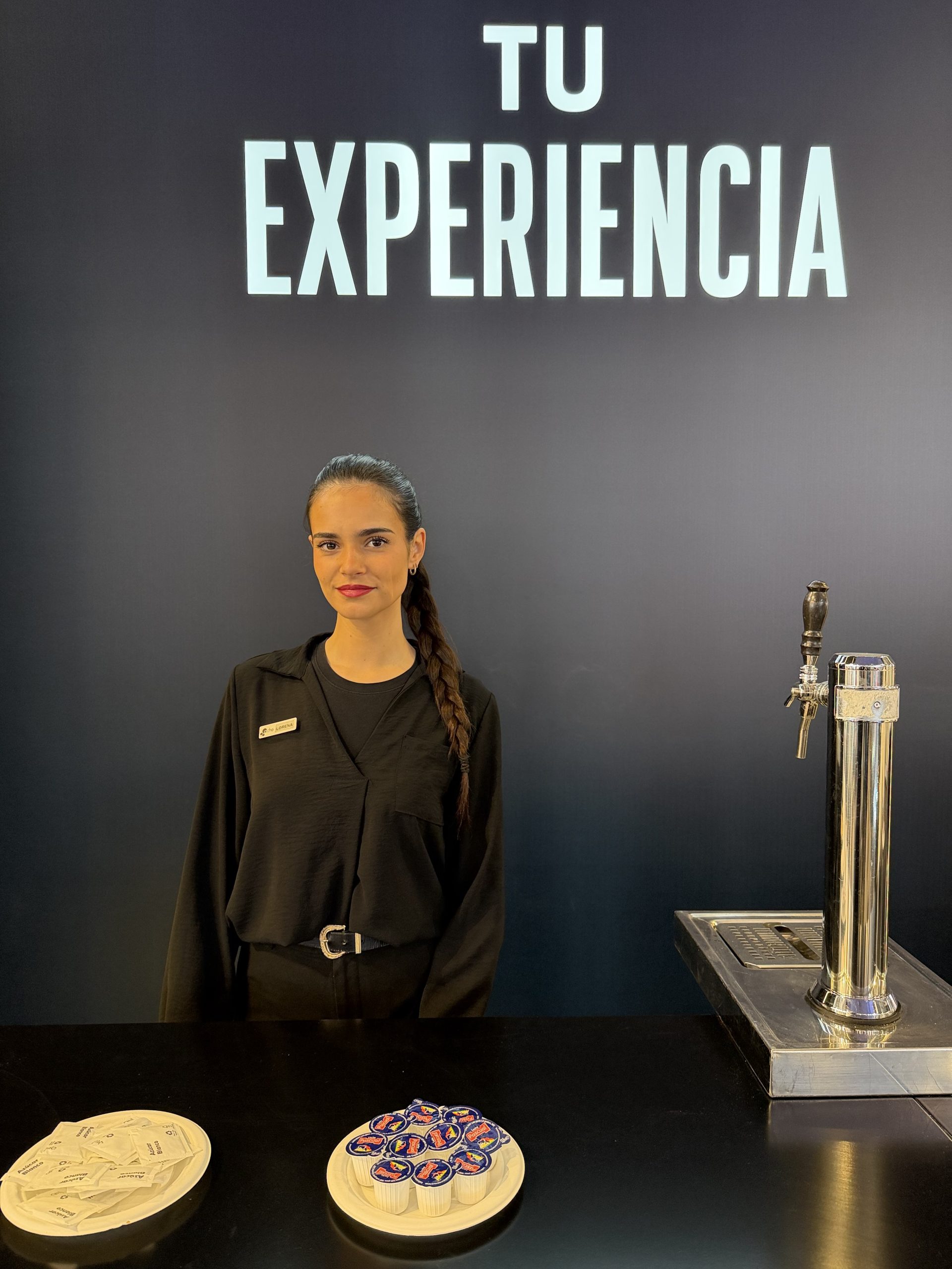 Camarera ofreciendo servicio en un stand durante la feria FITUR 2026.